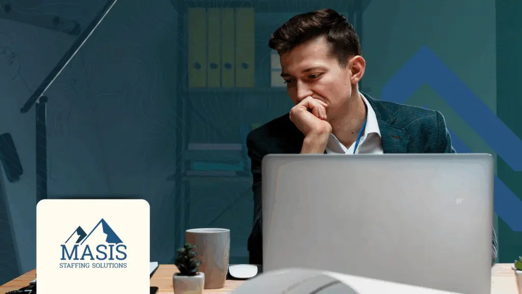 A man in front of a computer, deeply thinking.