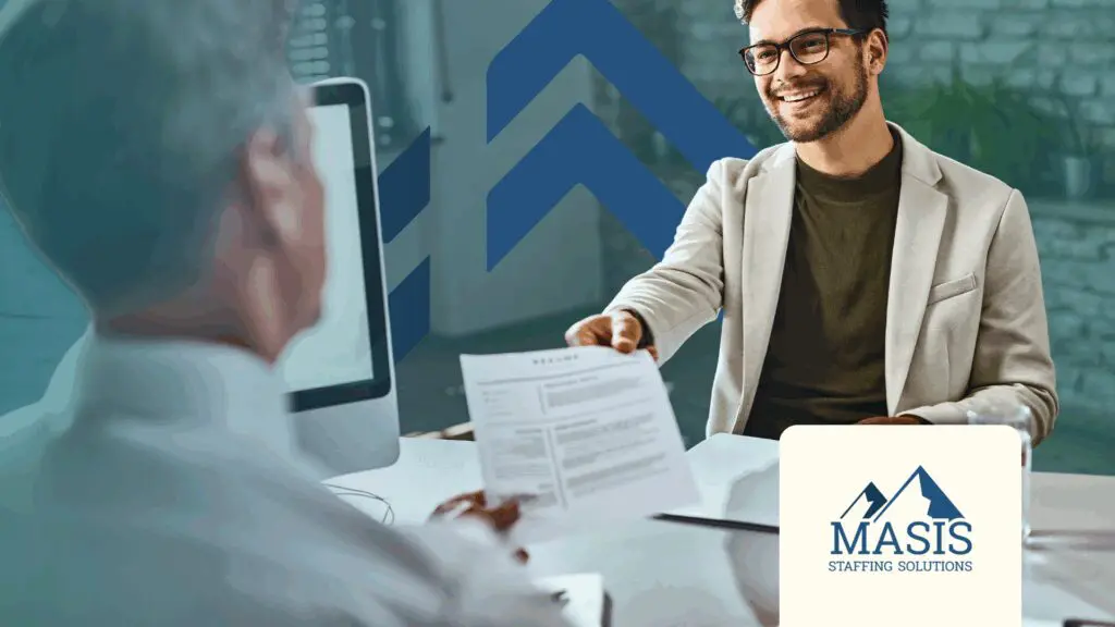 Smiling job applicant handing resume to interviewer