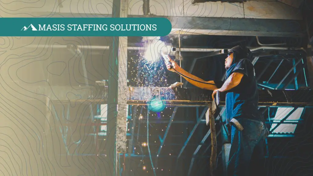 Man in protective gear welding metal