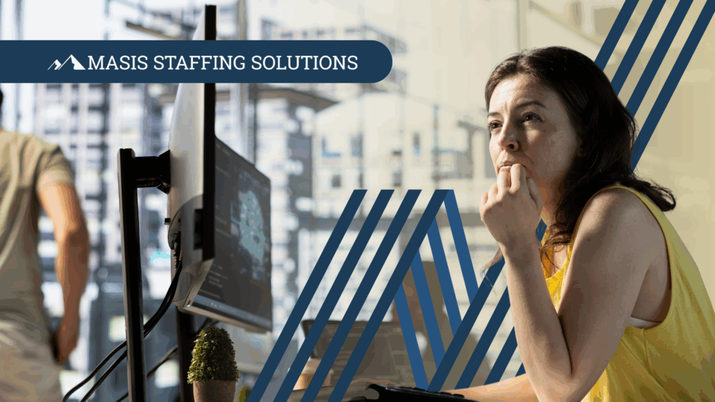 Employee sits at a desk looking at a computer monitor