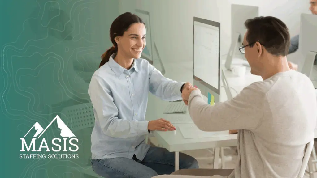 A recruiter and candidate shake hands, illustrating hiring trends