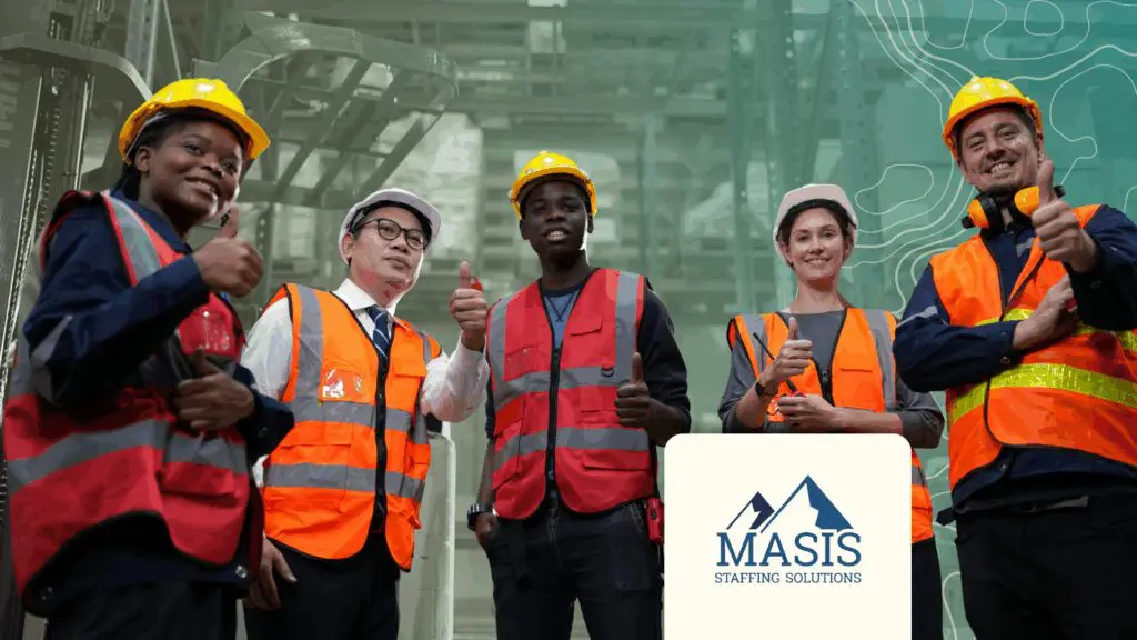 Warehouse workers stand smiling with thumbs up signs