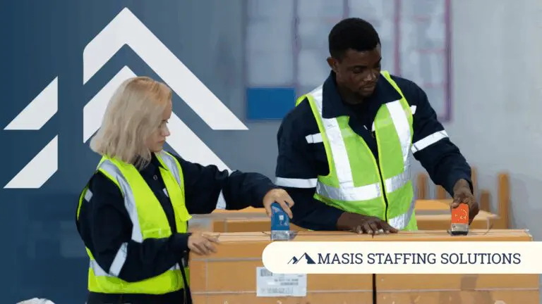 Two logistics employees pack a large box