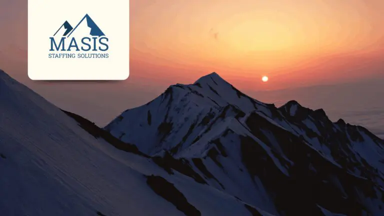 A sunset seen over mountain peaks that reflect Masis' logo.