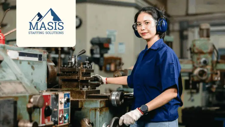 Manufacturing employee wearing safety hearing equipment operates machinery