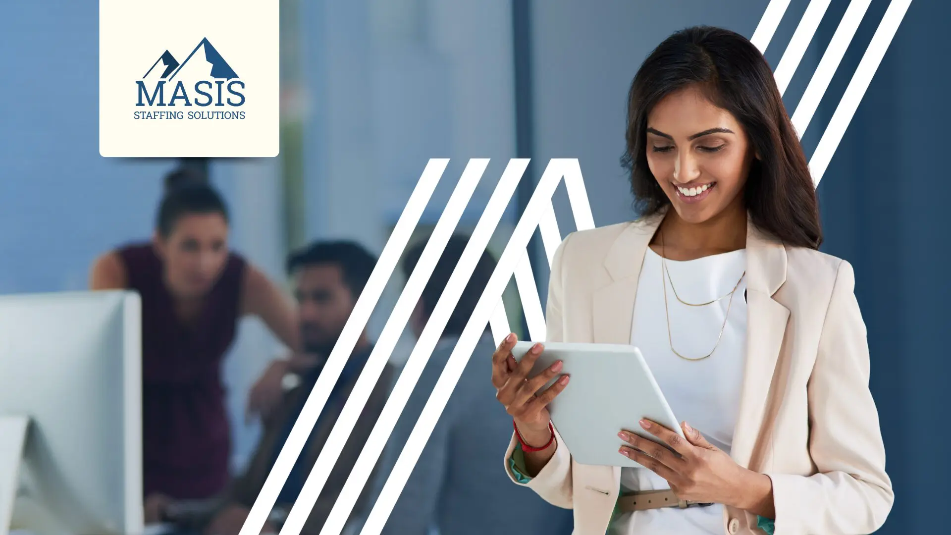 Admin staff stands holding a mobile tablet in the office