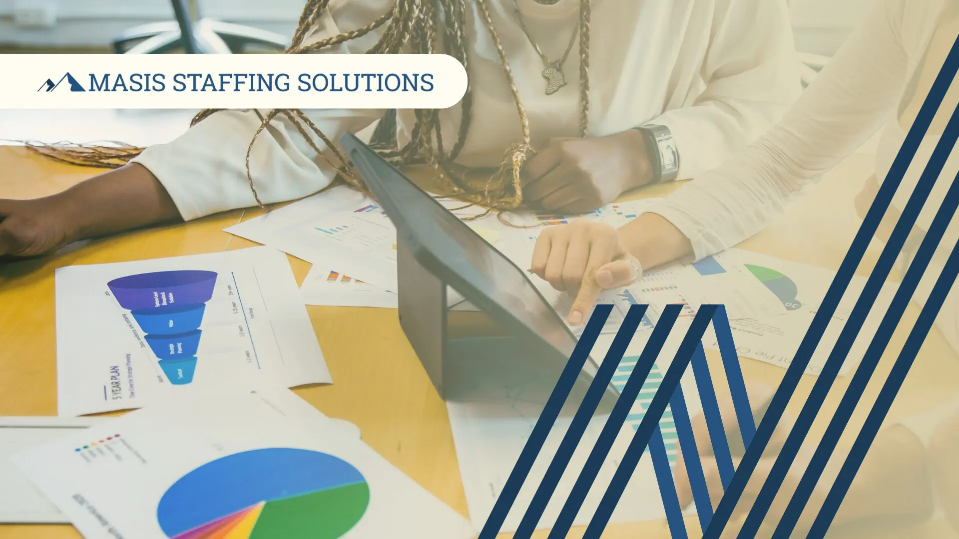 Professionals work at a table covered in papers displaying staffing analytics