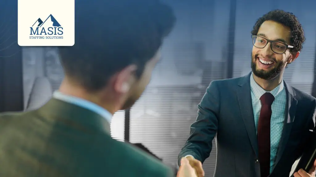A smiling applicant shakes hands with a recruiter, illustrating good candidate experience