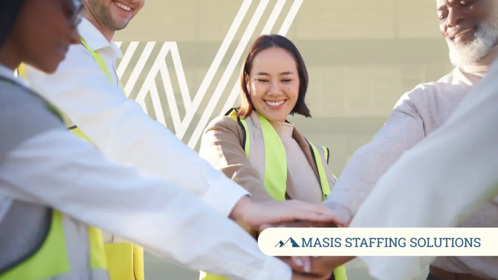 Light industrial employees put their hands together, symbolizing team loyalty in high-turnover industries