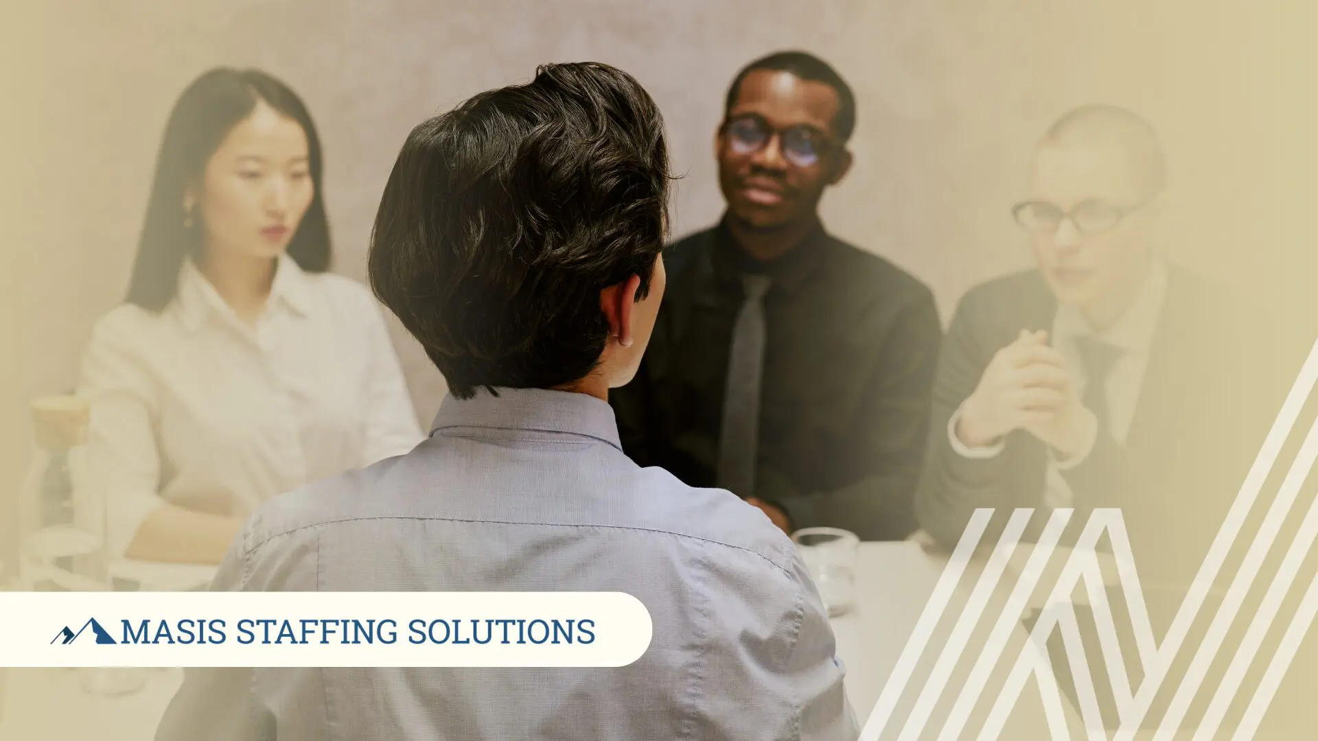 A candidate sits across from two interviewers at a table, representing the interview process and the feedback opportunity that follows every interview.