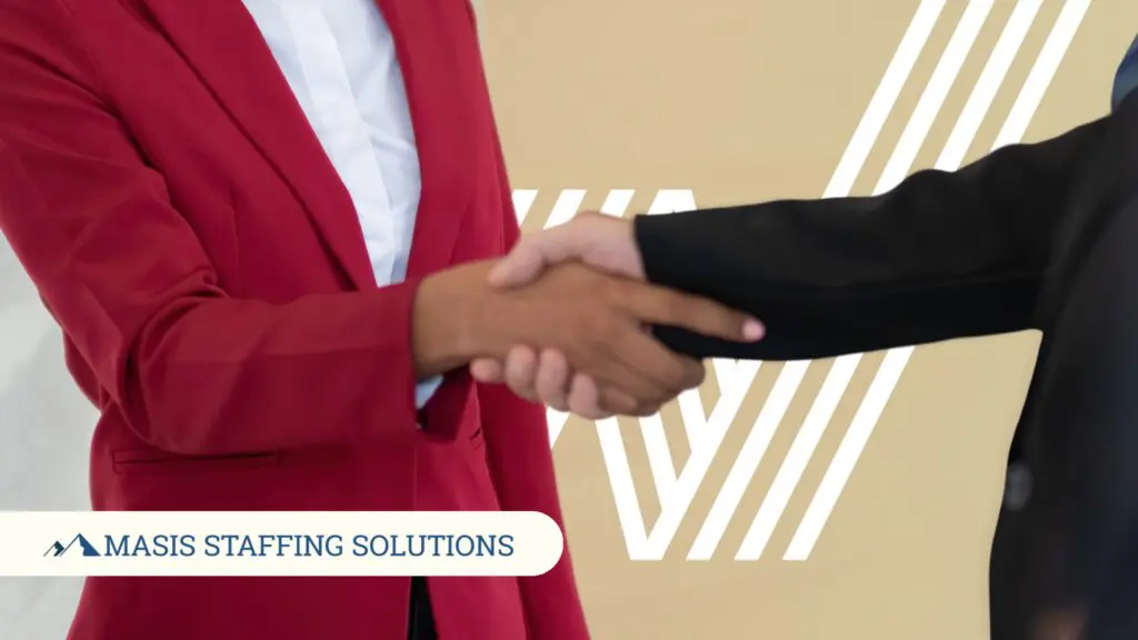 Two professionals shake hands, representing the moment a candidate accepts a job offer and prepares to make a great first impression.