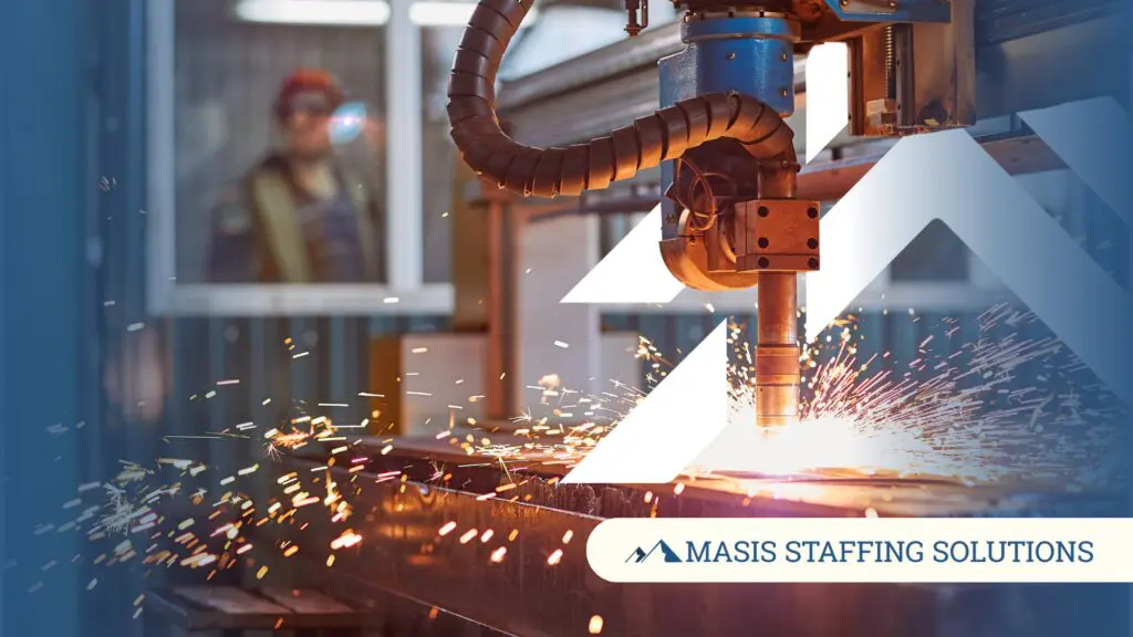 A skilled worker monitors industrial welding machinery on a manufacturing floor, representing the high-demand skilled labor environments Masis supports when hiring needs spike.