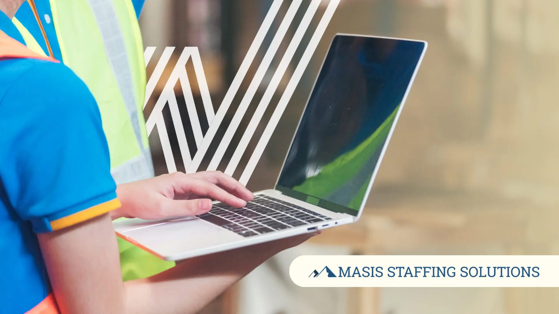 A worker in a safety vest types on a laptop, representing a temp worker taking initiative to pursue a permanent role.