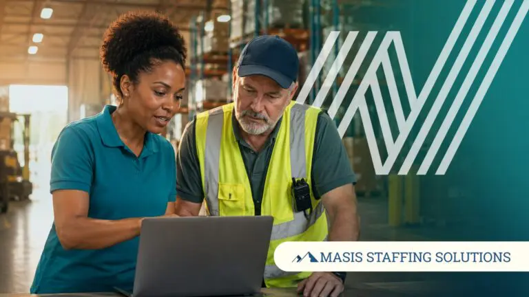 A recruiter reviews a laptop with a warehouse worker, showing what working with a staffing agency looks like