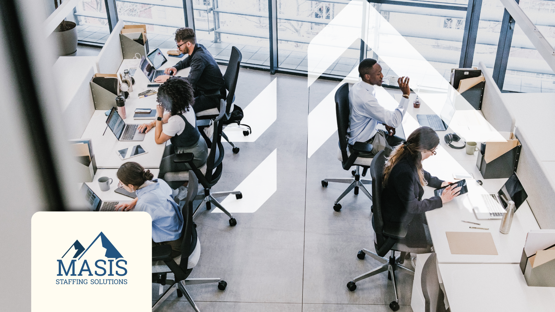 Busy employees in a well-lit open-plan office viewed from above