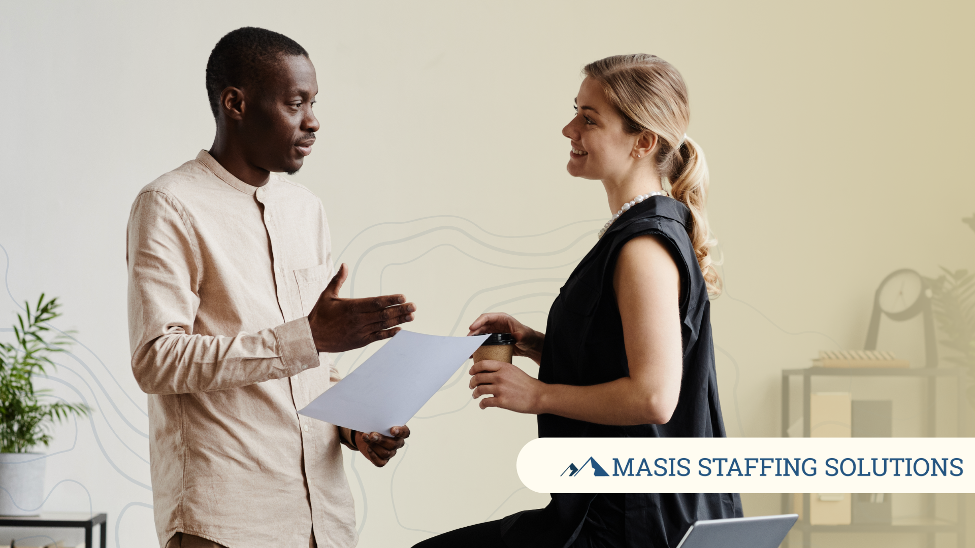 Two office employees speak to each other, demonstrating soft skills