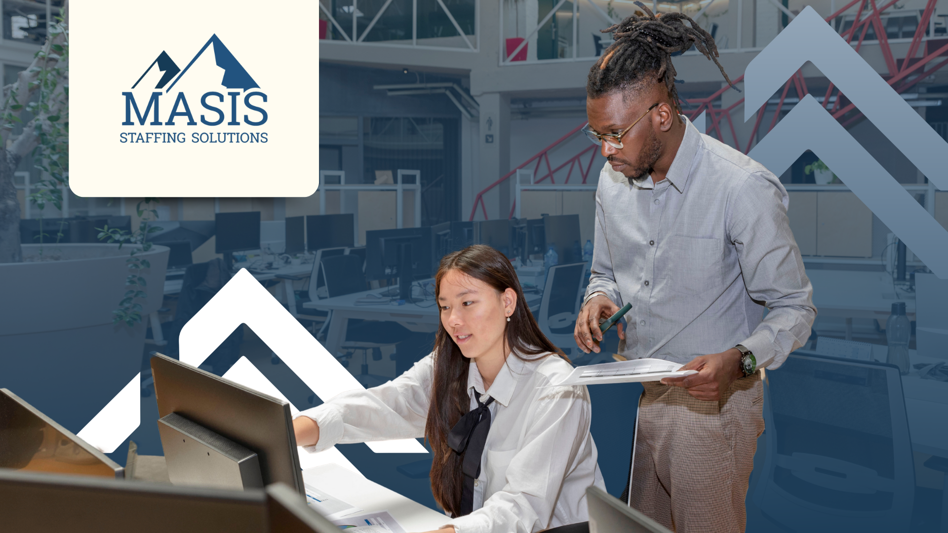 A season hire discusses work with a permanent employee at an office desk