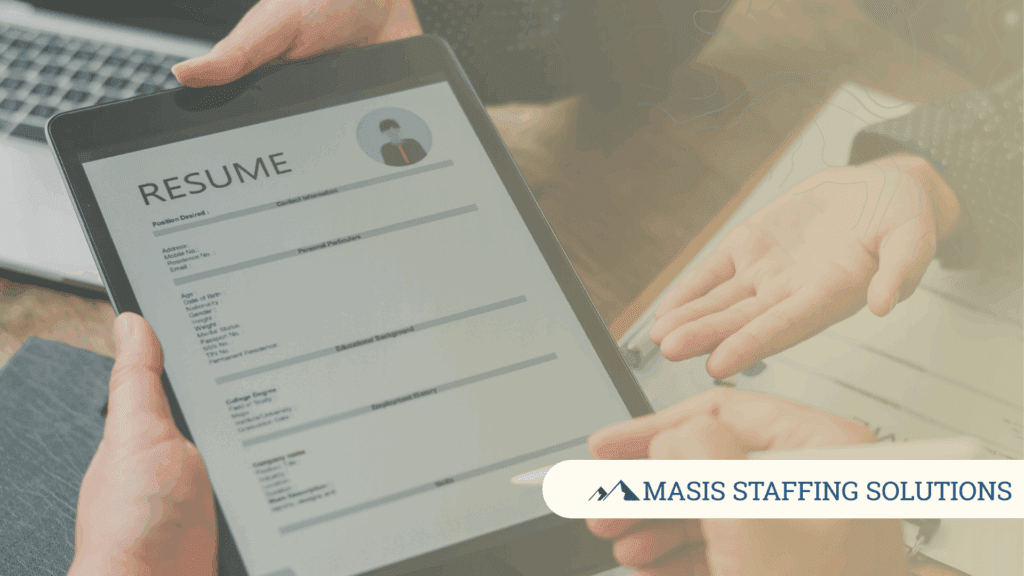 A resume format on a mobile tablet is passed between hiring manager and employee