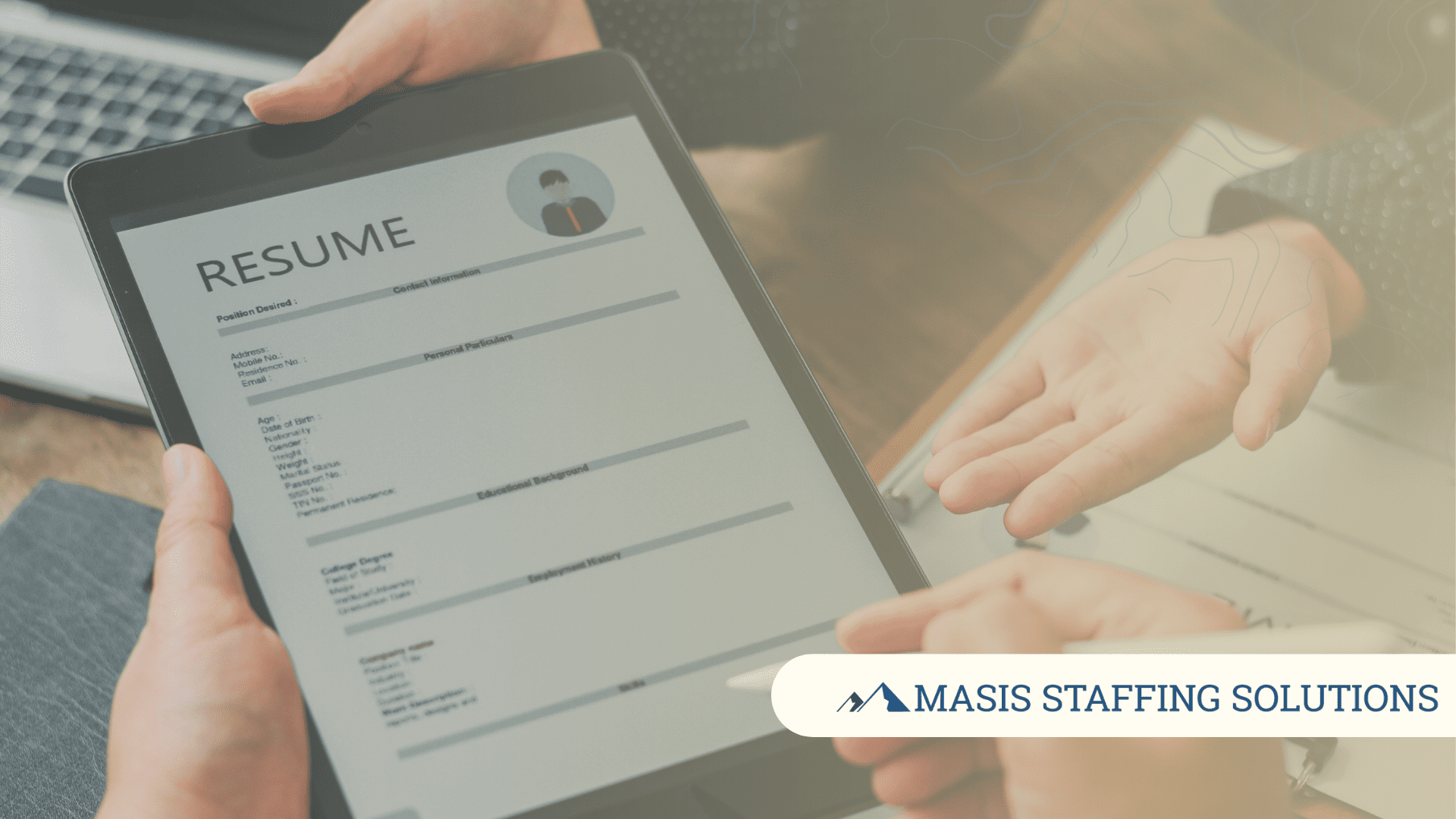 A resume format on a mobile tablet is passed between hiring manager and employee