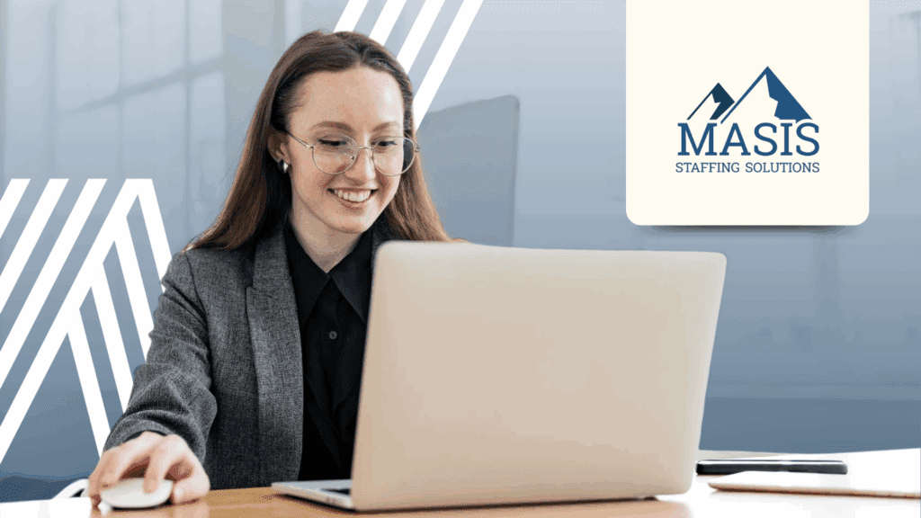 Temporary employee in corporate attire works on a laptop at an office desk