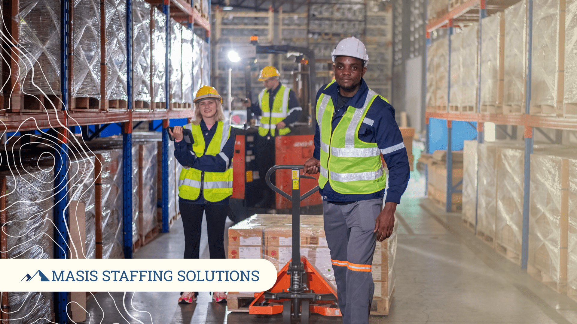 Three warehouse employees stand smiling in a warehouse